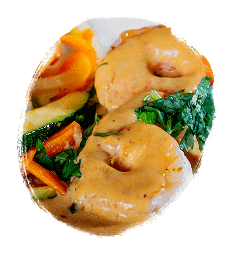 Shrimp topped with an orange sauce and paired with fresh vegetables