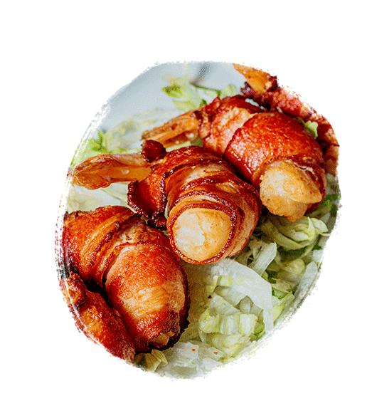 Bacon wrapped shrimp on a bed of lettuce